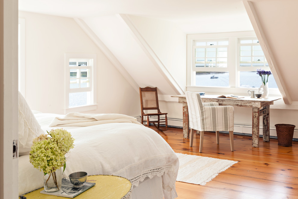 Example of a beach style master medium tone wood floor bedroom design in Boston with white walls