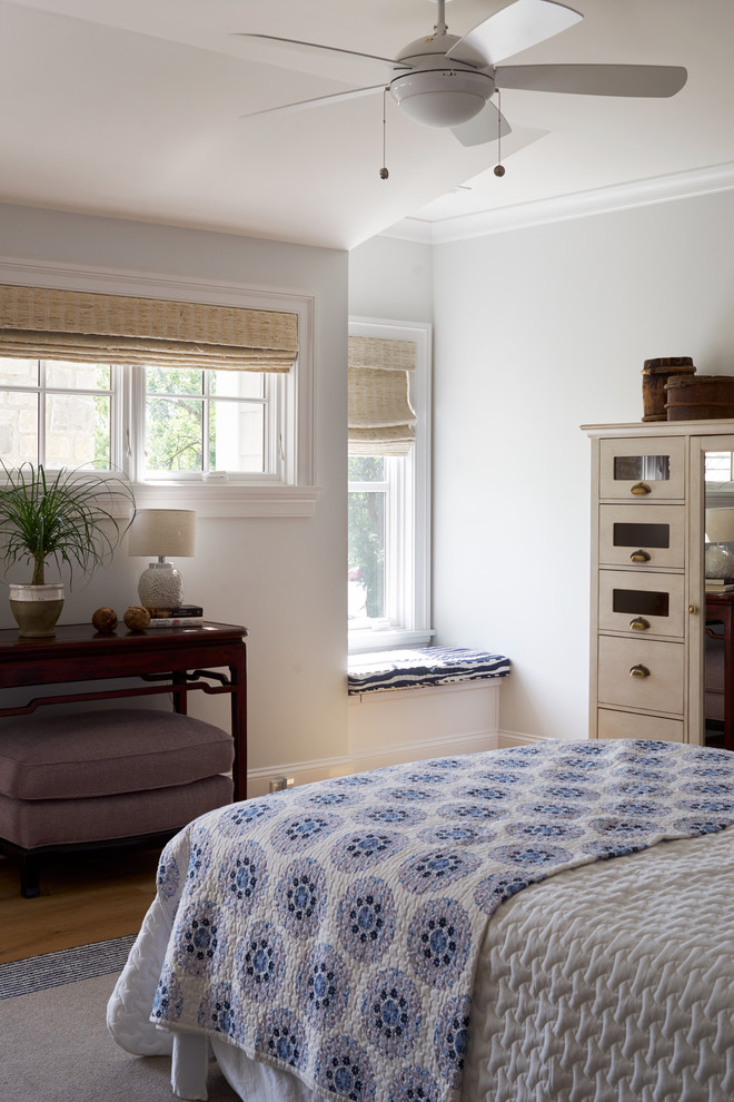 Modelo de habitación de invitados costera de tamaño medio con paredes azules, suelo de madera clara y suelo marrón