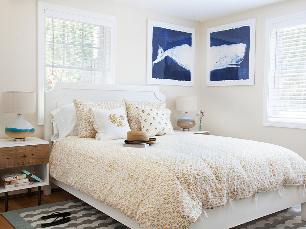 Immagine di una camera degli ospiti stile marino con pareti beige e pavimento in legno massello medio