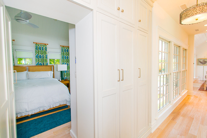 Photo of a large beach style master bedroom in Philadelphia with white walls and light hardwood flooring.