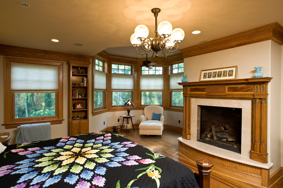 Aménagement d'une chambre d'amis victorienne de taille moyenne avec un mur beige, une cheminée standard, un sol en bois brun et un manteau de cheminée en bois.