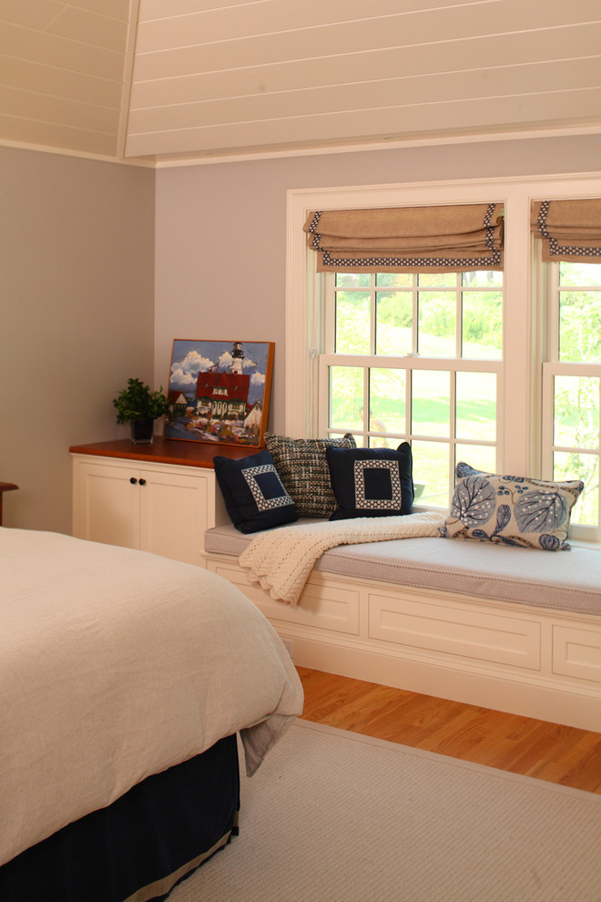 Cette photo montre une chambre chic de taille moyenne avec un mur gris, un sol en bois brun et un sol beige.