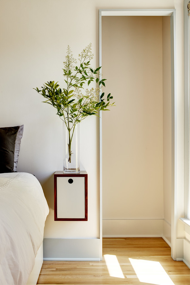 Ispirazione per una piccola camera matrimoniale minimalista con pareti bianche e parquet chiaro