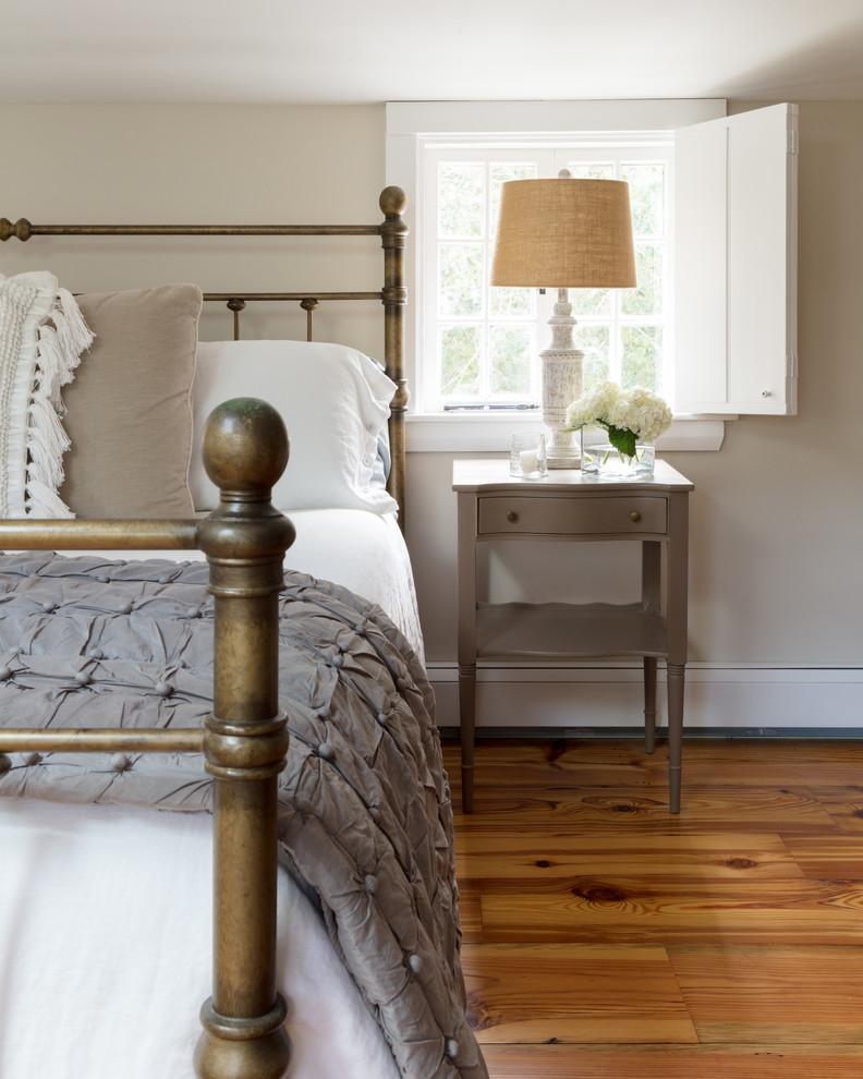Ejemplo de habitación de invitados campestre de tamaño medio con suelo de madera en tonos medios y suelo marrón