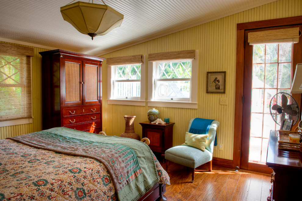 Esempio di una camera degli ospiti stile marino di medie dimensioni con pareti gialle e pavimento in legno massello medio