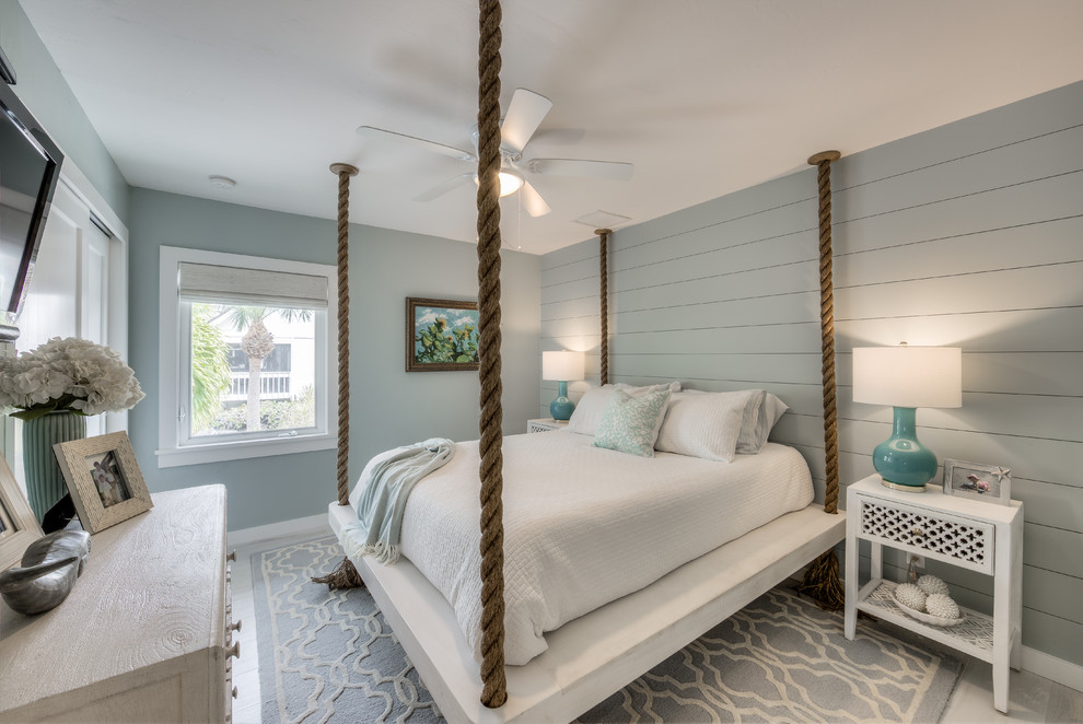 This is an example of a beach style bedroom in Philadelphia with blue walls and beige floors.