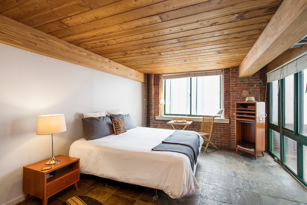 Imagen de habitación de invitados minimalista grande sin chimenea con paredes blancas, suelo de pizarra y suelo gris