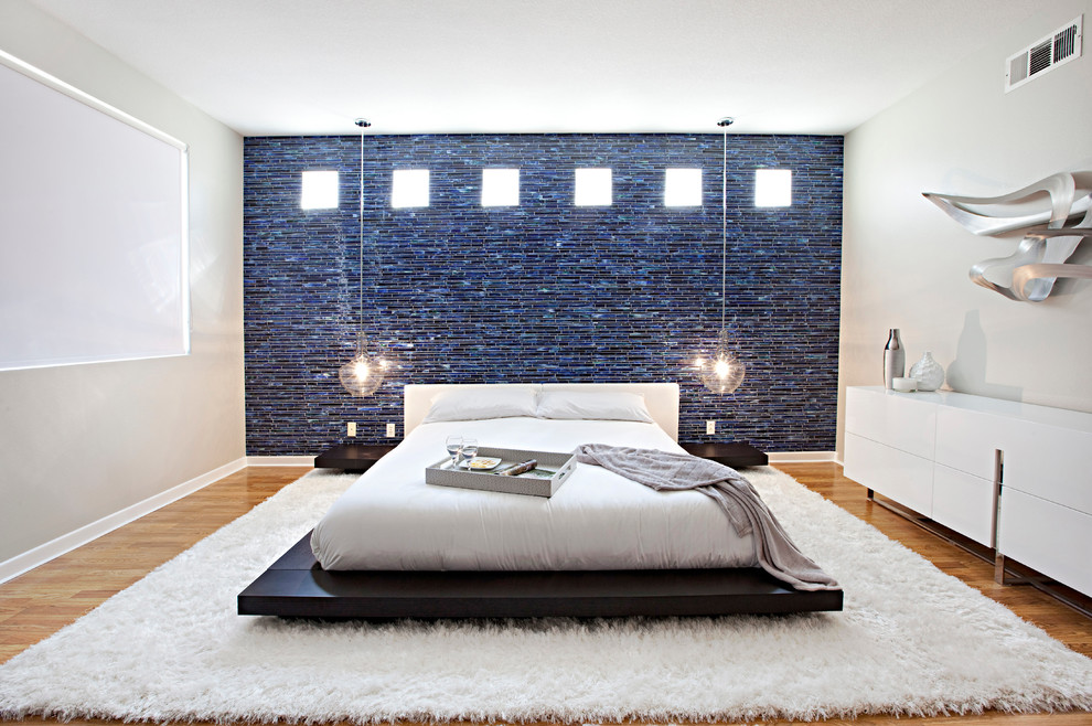 Exemple d'une grande chambre parentale tendance avec un mur beige et un sol en bois brun.