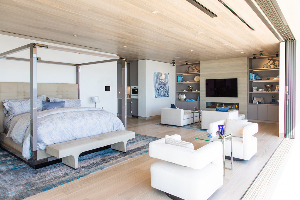 Modernes Schlafzimmer mit weißer Wandfarbe, hellem Holzboden, Gaskamin und beigem Boden in Los Angeles