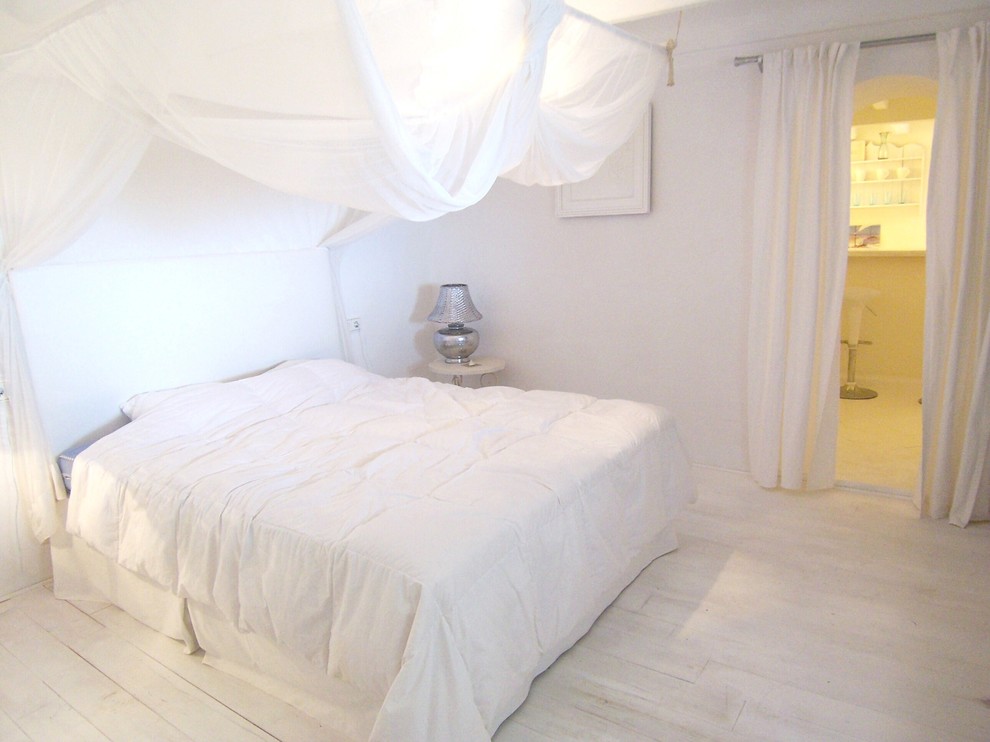 マヨルカ島にある中くらいな地中海スタイルのおしゃれな主寝室 (白い壁、塗装フローリング、暖炉なし、白い床) のレイアウト