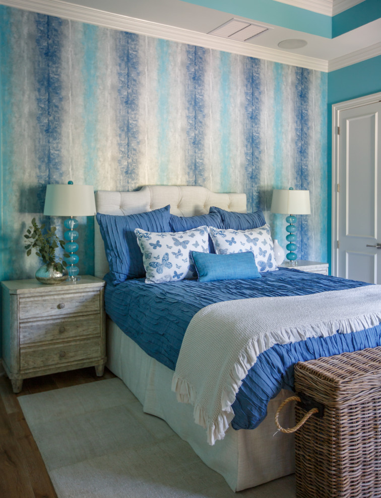 This is an example of a coastal guest bedroom in Jacksonville with blue walls and medium hardwood flooring.