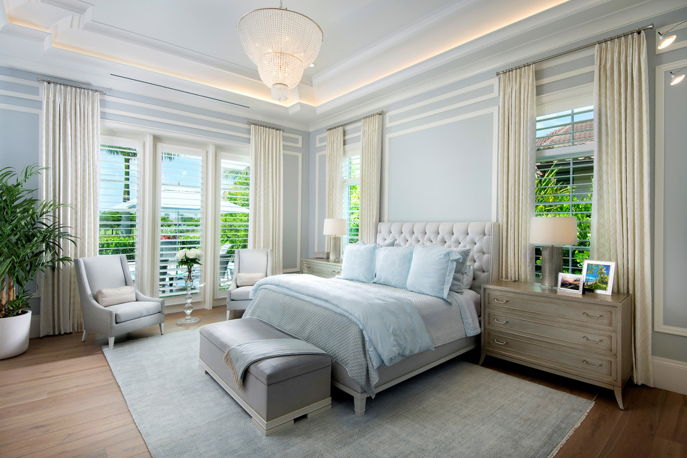 Mediterranes Schlafzimmer mit blauer Wandfarbe und braunem Holzboden in Miami