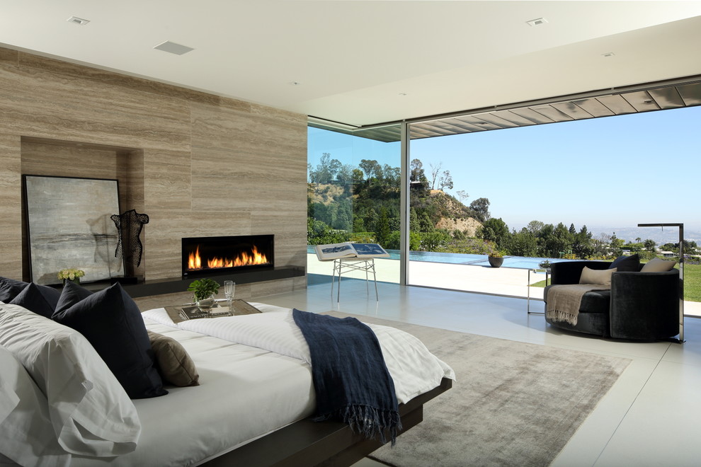 ロサンゼルスにある巨大なモダンスタイルのおしゃれな主寝室 (ベージュの壁、セラミックタイルの床、横長型暖炉、タイルの暖炉まわり、ベージュの床) のインテリア