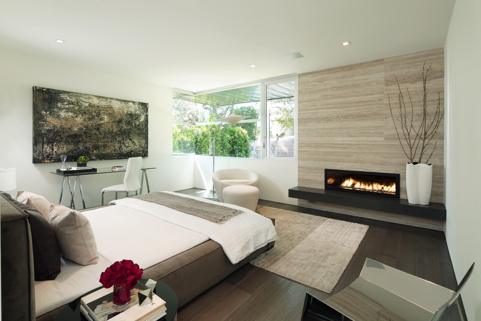 ロサンゼルスにある広いコンテンポラリースタイルのおしゃれな客用寝室 (白い壁、濃色無垢フローリング、横長型暖炉、タイルの暖炉まわり、茶色い床) のインテリア