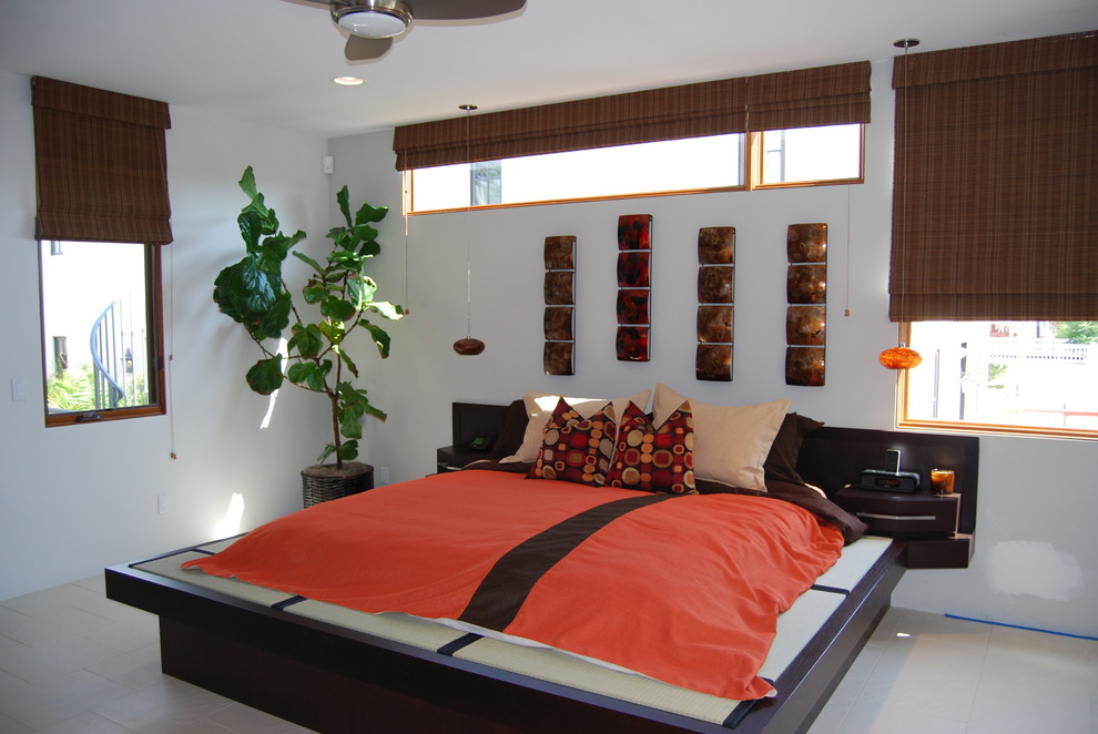 Cette image montre une chambre parentale minimaliste de taille moyenne avec un mur blanc et un sol en calcaire.
