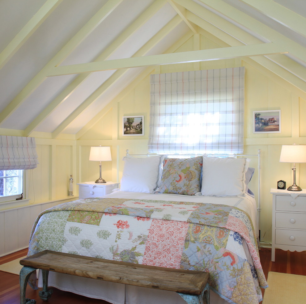 Esempio di una camera da letto costiera con pareti gialle, pavimento in legno massello medio e nessun camino