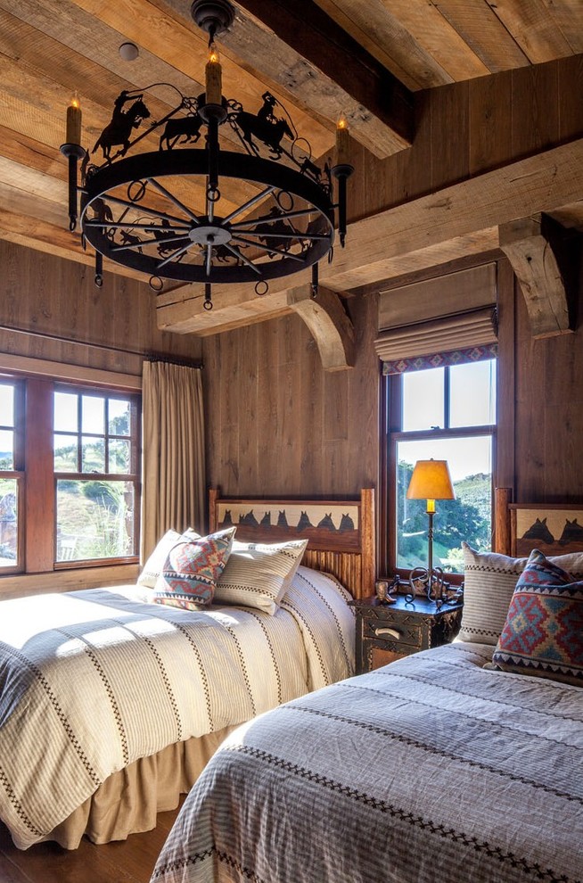Inspiration for a rustic guest bedroom in Denver with brown walls, dark hardwood flooring, no fireplace, brown floors and feature lighting.
