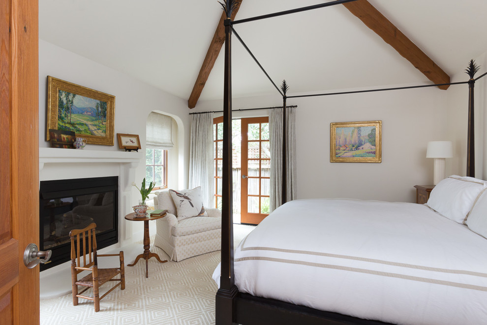 Imagen de dormitorio principal clásico pequeño con paredes beige, moqueta, todas las chimeneas y marco de chimenea de yeso