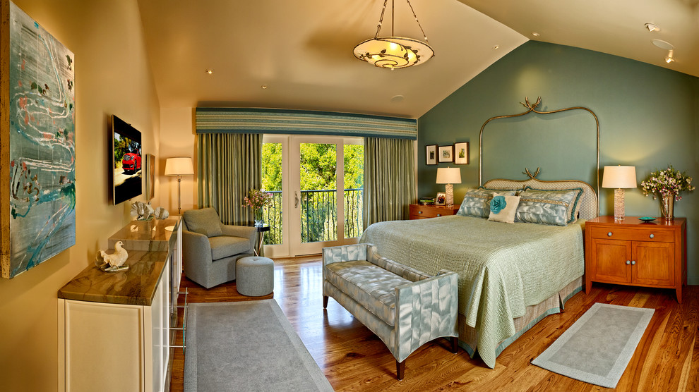 Foto de dormitorio principal clásico renovado grande con paredes verdes, suelo de madera clara, todas las chimeneas y marco de chimenea de piedra