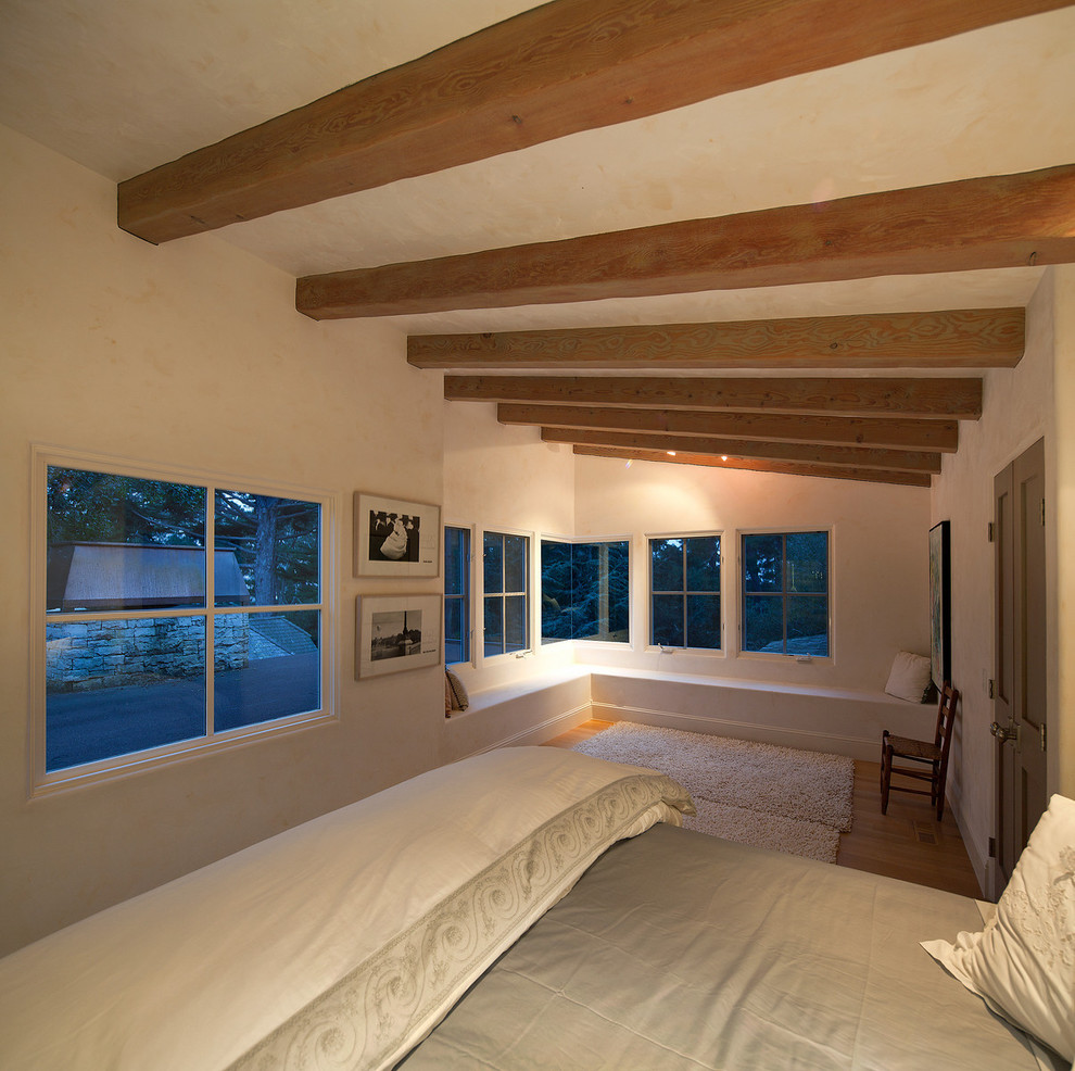 Idée de décoration pour une chambre chalet avec un mur beige et un sol en bois brun.