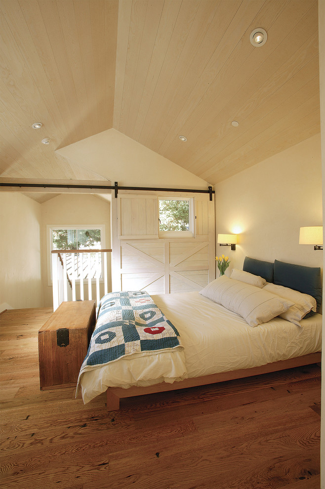 Modelo de dormitorio campestre sin chimenea con paredes blancas y suelo de madera en tonos medios