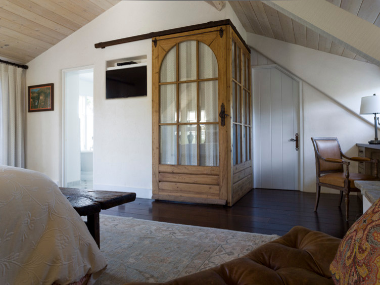 На фото: маленькая хозяйская спальня в стиле рустика с белыми стенами и темным паркетным полом для на участке и в саду