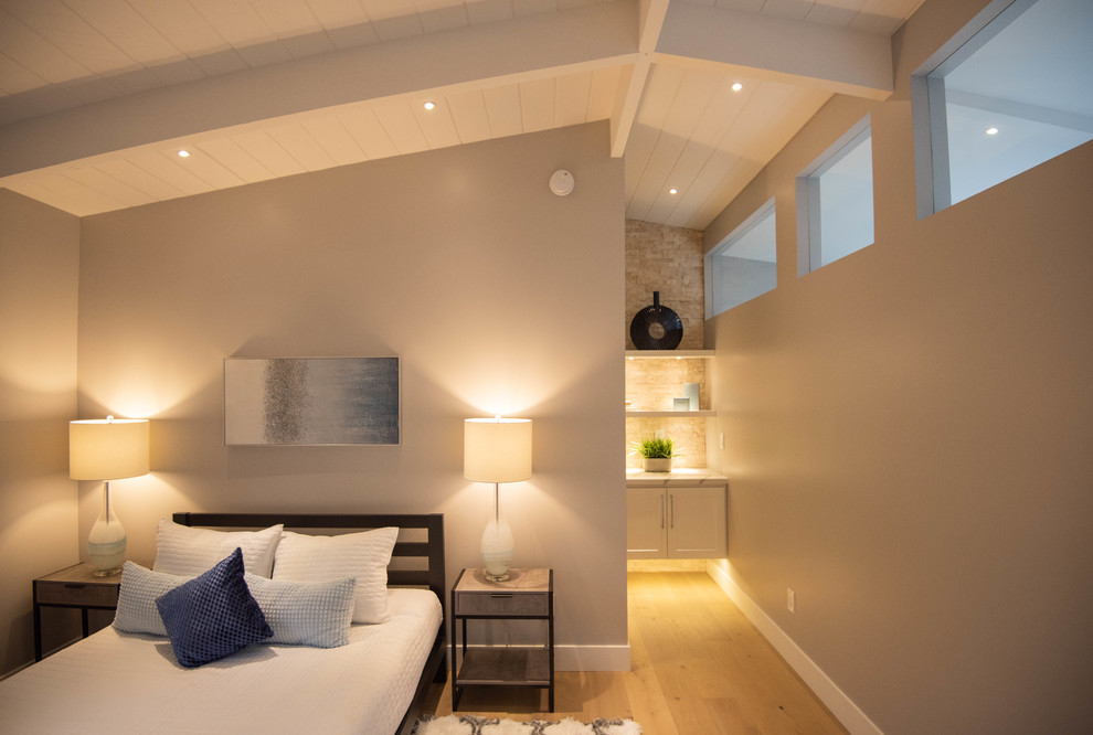 Esempio di una camera degli ospiti minimalista di medie dimensioni con pareti grigie, parquet chiaro e pavimento marrone