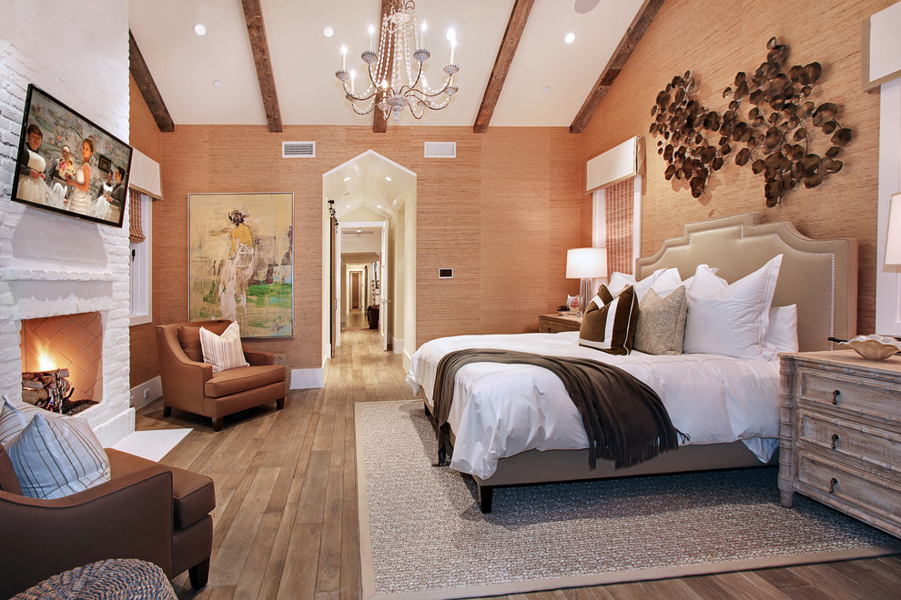 Klassisches Schlafzimmer mit beiger Wandfarbe, Kamin und Kaminumrandung aus Backstein in Orange County