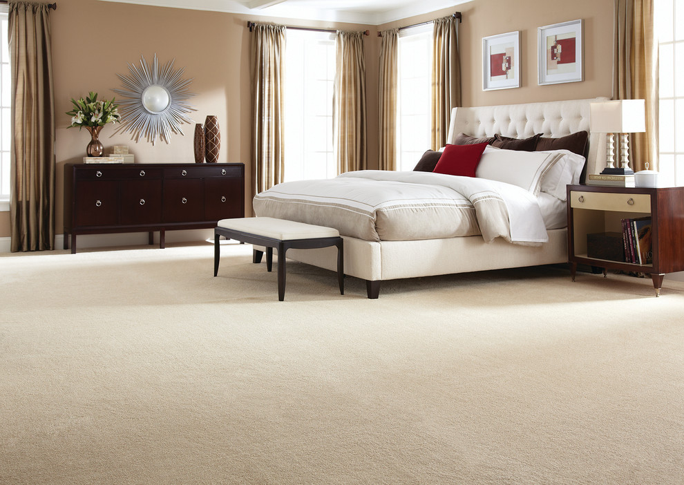 Inspiration for a large traditional master bedroom in New York with beige walls, carpet and no fireplace.