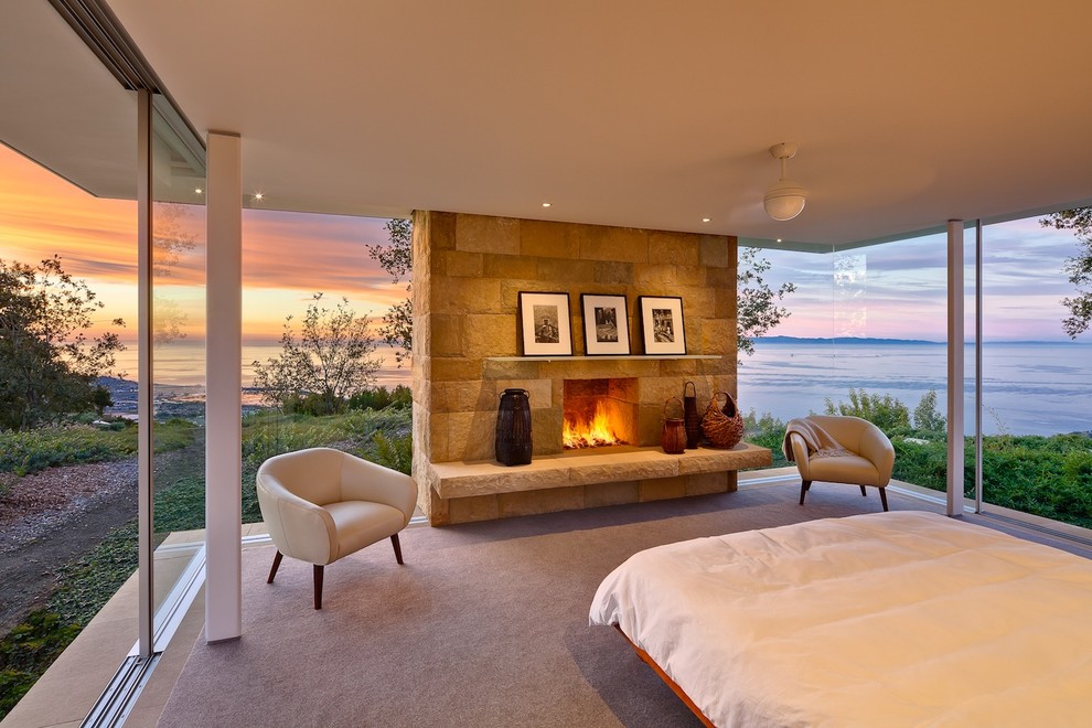 This is an example of a modern bedroom in Santa Barbara with carpet, a standard fireplace and a stone fireplace surround.