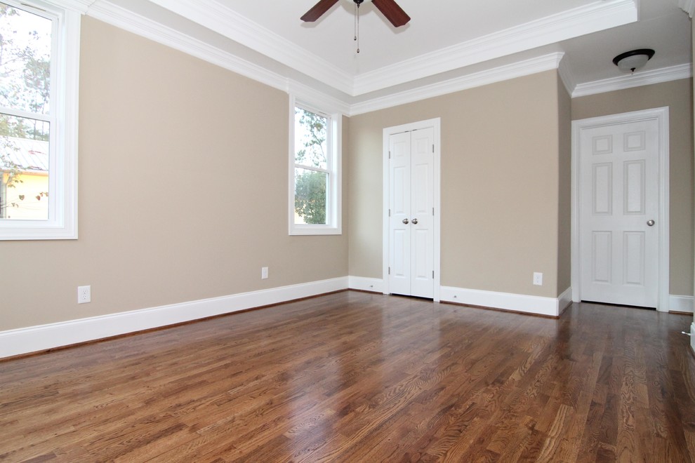 Réalisation d'une chambre parentale craftsman de taille moyenne avec un mur beige et un sol en bois brun.