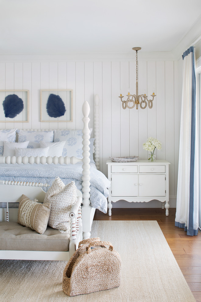 Inspiration for a large coastal master medium tone wood floor and brown floor bedroom remodel in Miami with white walls and no fireplace