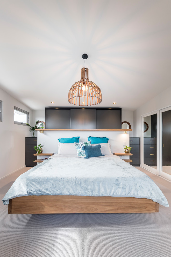 Example of an island style light wood floor and beige floor bedroom design in Newcastle - Maitland with white walls