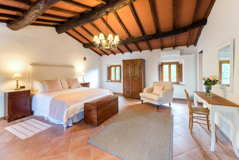 Свежая идея для дизайна: хозяйская спальня среднего размера в средиземноморском стиле с белыми стенами, полом из терракотовой плитки и оранжевым полом - отличное фото интерьера