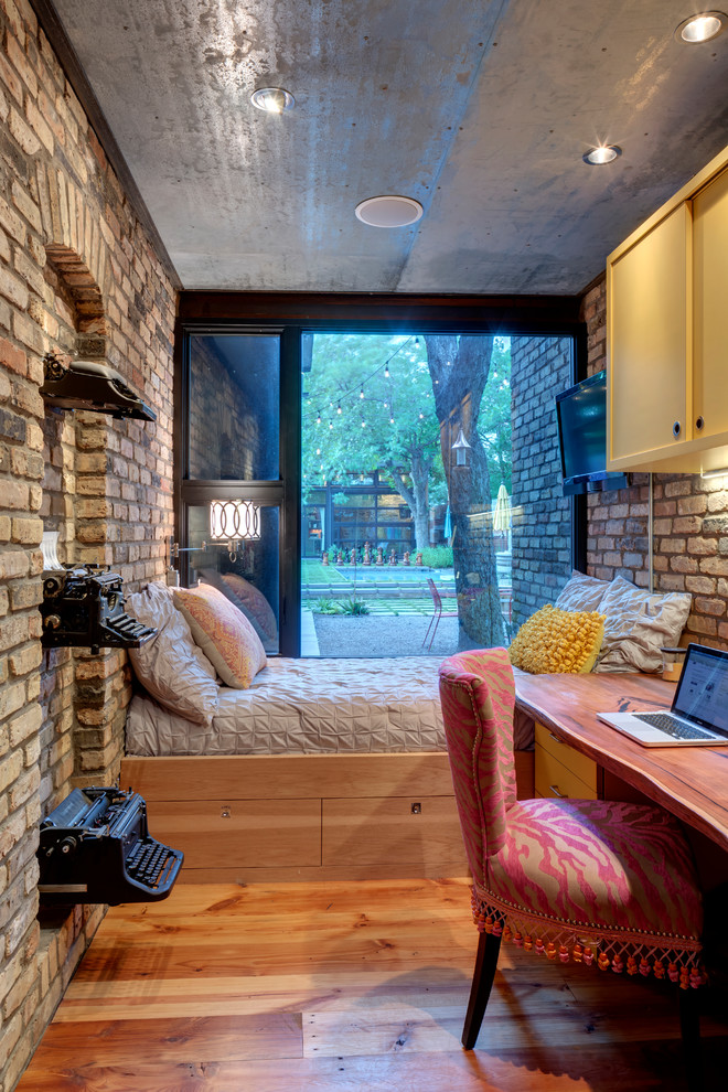 Ejemplo de dormitorio urbano pequeño con suelo de madera en tonos medios y con escritorio