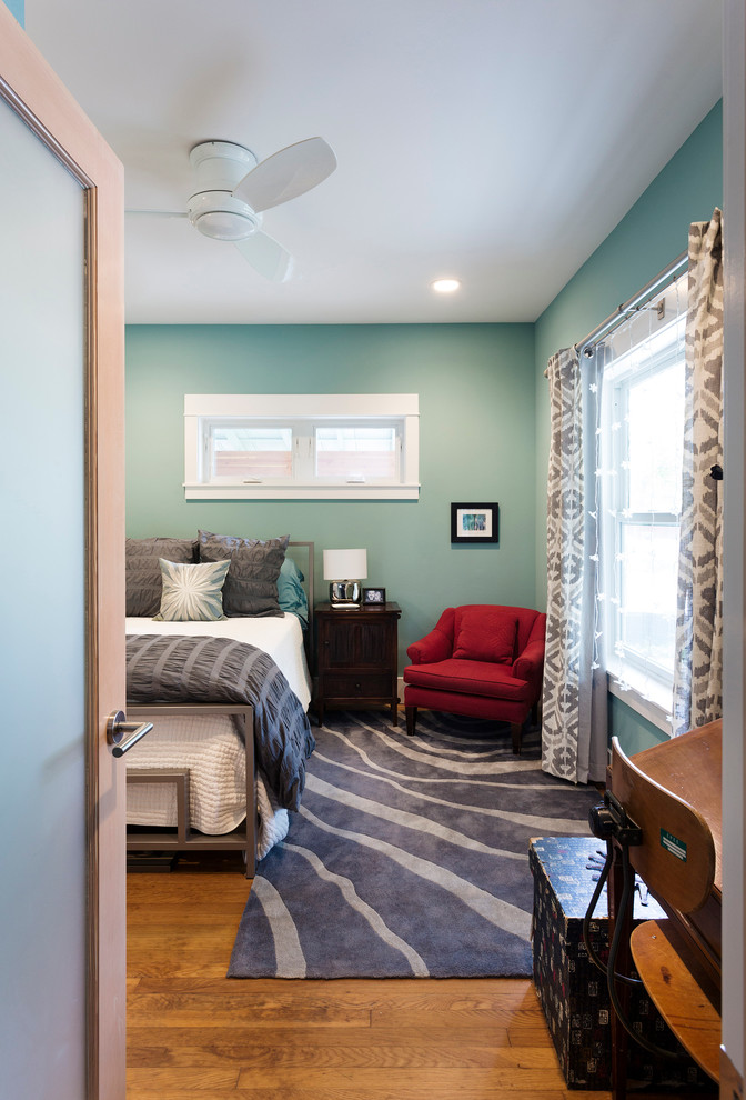 Esempio di una piccola camera degli ospiti minimal con pareti blu e pavimento in legno massello medio