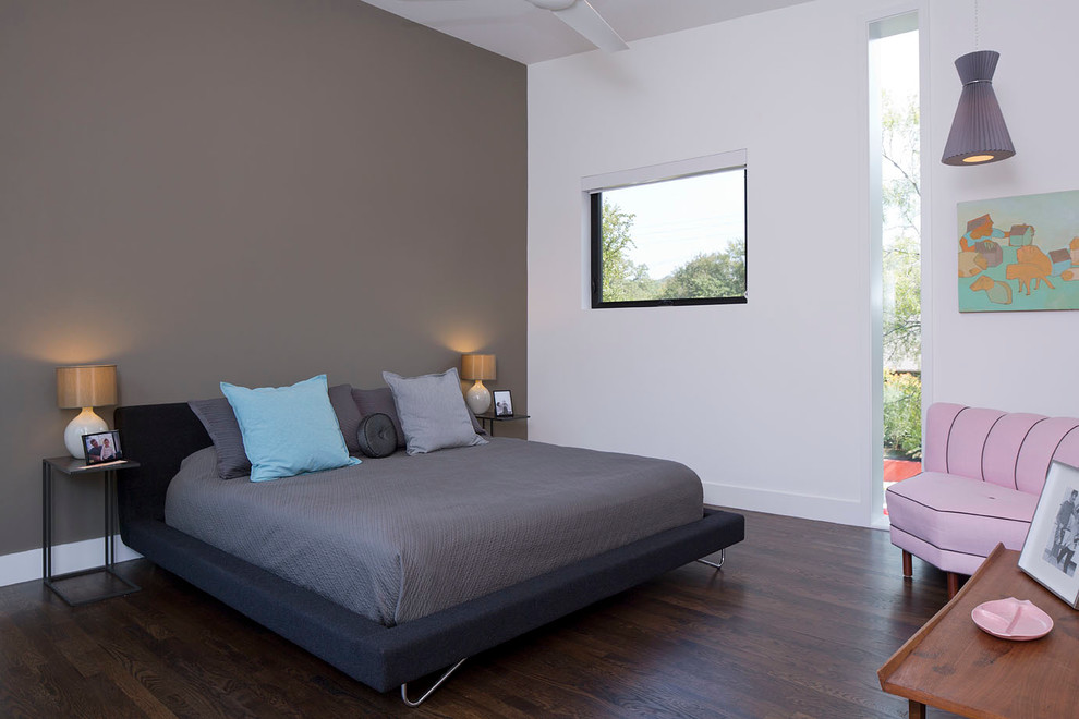 Kleines Modernes Hauptschlafzimmer ohne Kamin mit weißer Wandfarbe und dunklem Holzboden in Austin