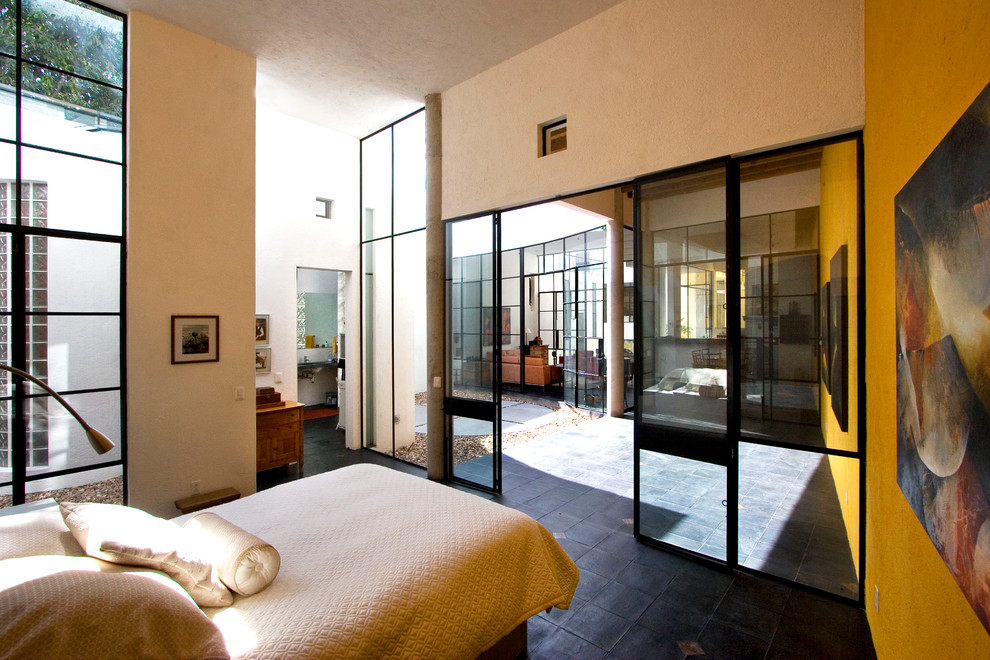 Imagen de dormitorio contemporáneo con paredes amarillas