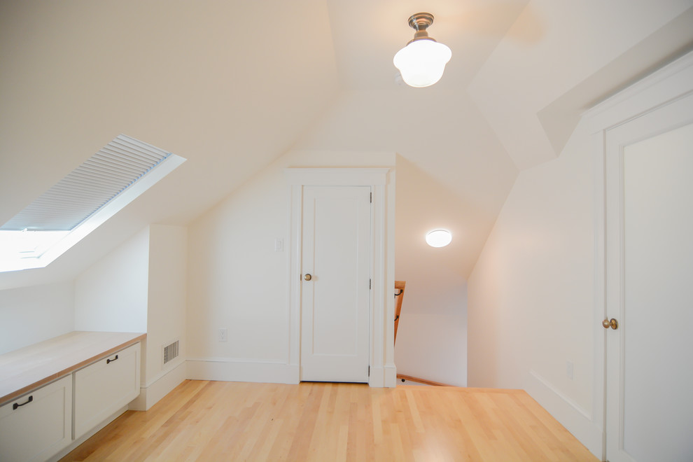Cette image montre une chambre parentale traditionnelle de taille moyenne avec un mur blanc et un sol en bois brun.