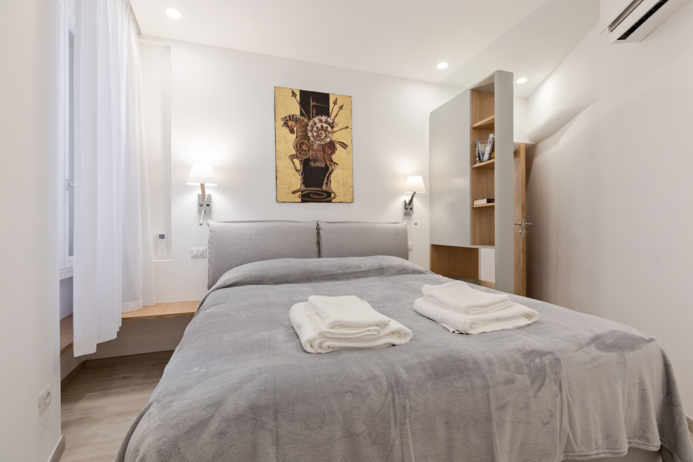 Example of a small trendy master porcelain tile and beige floor bedroom design in Rome with white walls and no fireplace