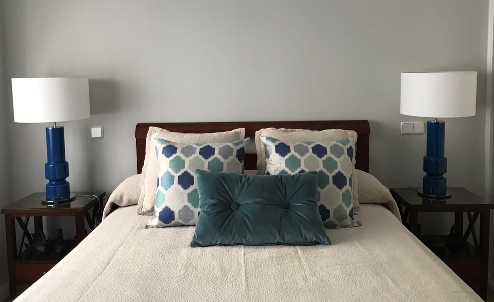 На фото: хозяйская спальня среднего размера в современном стиле с серыми стенами и полом из ламината с