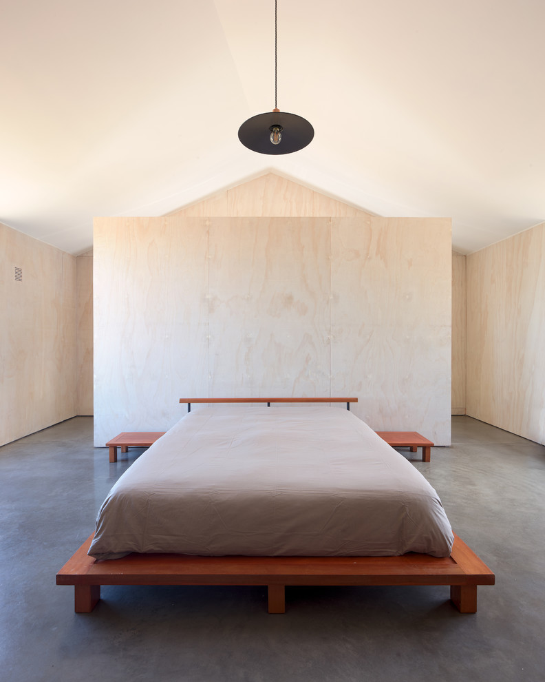 Esempio di una grande camera matrimoniale minimalista con pareti bianche, pavimento in cemento e pavimento grigio