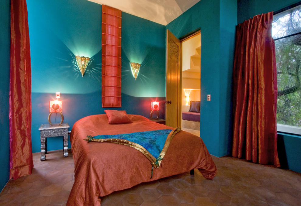 Foto på ett amerikanskt sovrum, med blå väggar, klinkergolv i terrakotta och rött golv