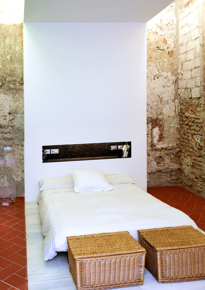 Ejemplo de dormitorio principal industrial de tamaño medio sin chimenea con paredes beige y suelo de baldosas de cerámica