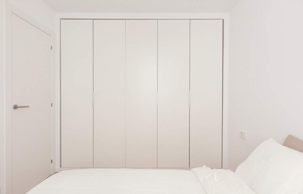 Ejemplo de dormitorio principal escandinavo pequeño sin chimenea con paredes blancas