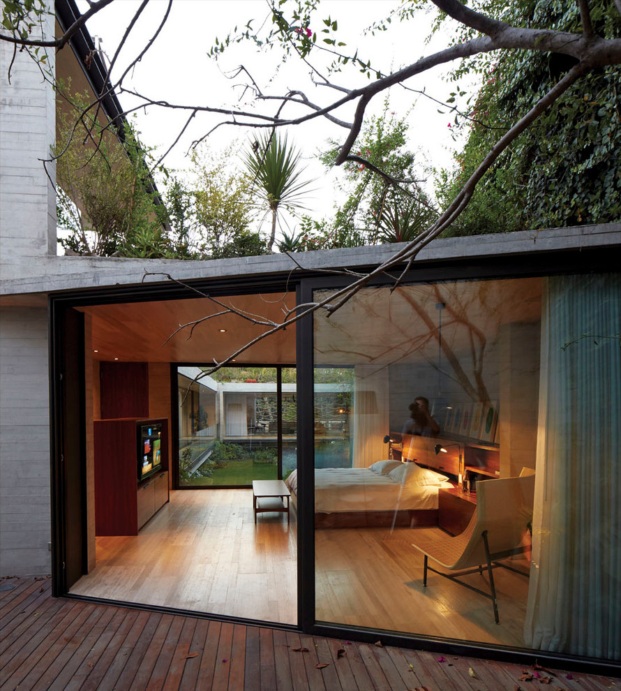 Inspiration för mellanstora moderna huvudsovrum, med grå väggar och ljust trägolv