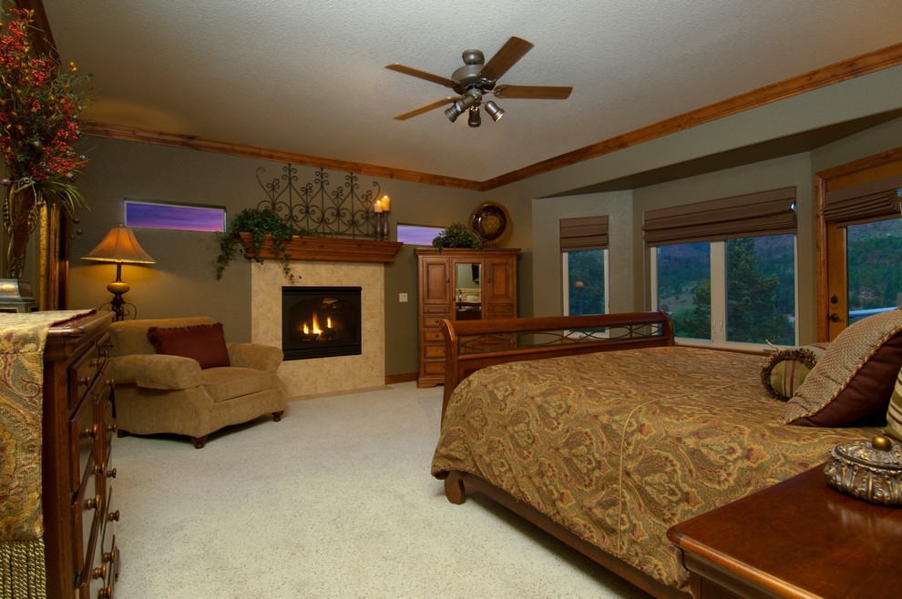 На фото: большая хозяйская спальня в классическом стиле с зелеными стенами, ковровым покрытием, стандартным камином и фасадом камина из плитки