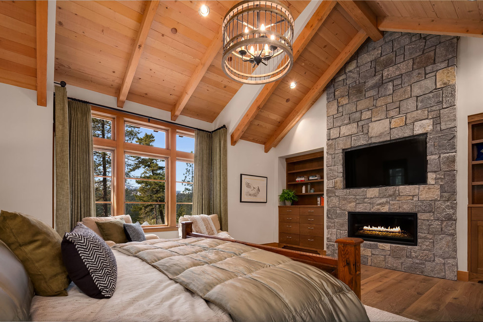 Imagen de dormitorio tradicional de tamaño medio con paredes beige, suelo de madera en tonos medios, todas las chimeneas y marco de chimenea de metal