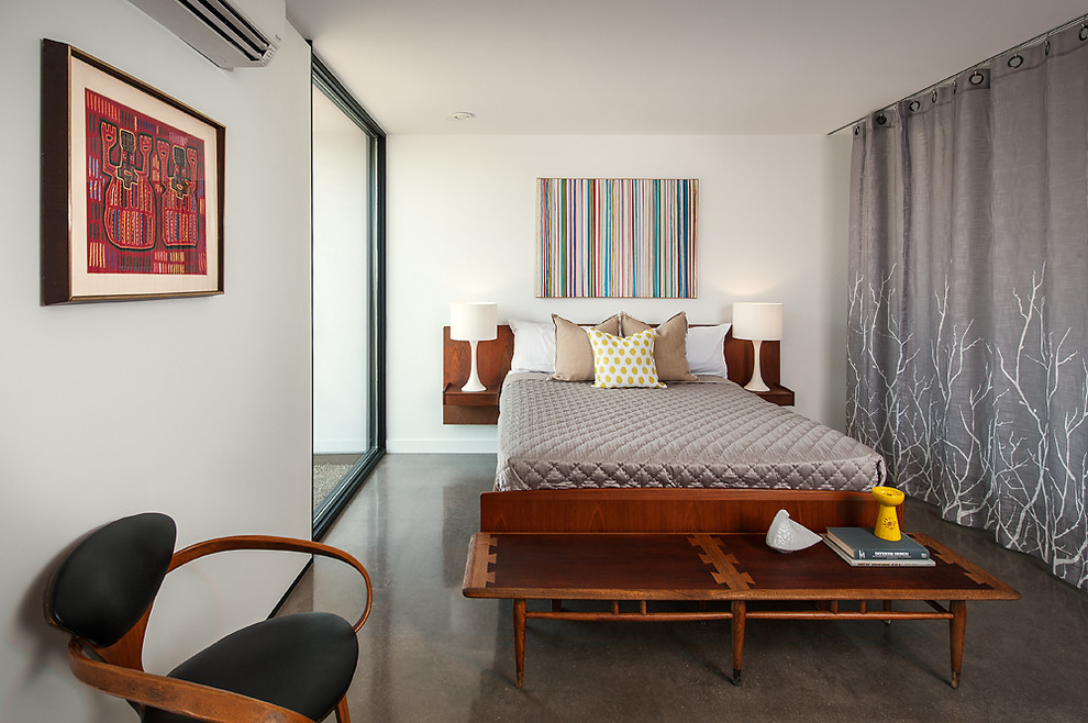 На фото: гостевая спальня среднего размера, (комната для гостей) в современном стиле с белыми стенами и бетонным полом с