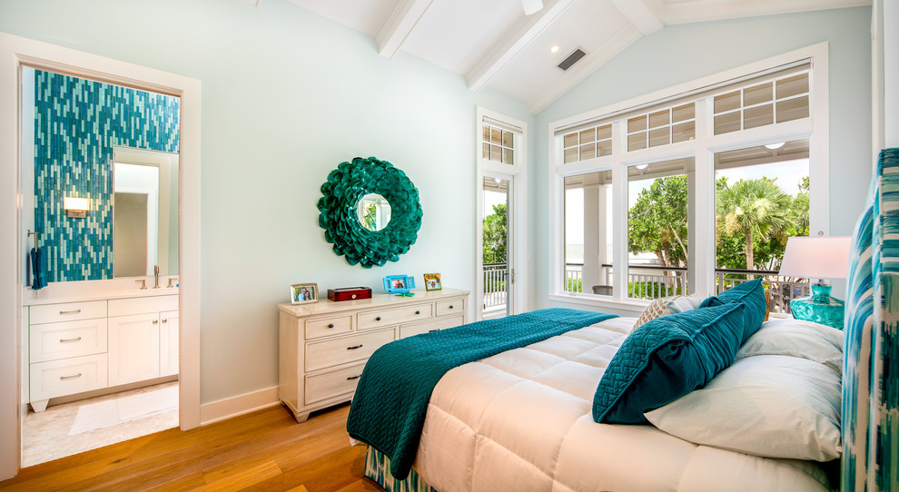 タンパにある中くらいなビーチスタイルのおしゃれな客用寝室 (青い壁、淡色無垢フローリング、茶色い床) のインテリア